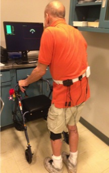 figure-results-1 Gait analysis experiment using sensors; man with walker monitors movement patterns on screen.