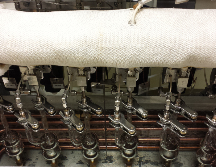 Vacuum line setup for gas collection in chemical experiment; glass and metal apparatus shown.