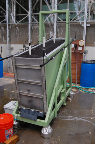 Soil erosion study setup; inclined flume with sediment layers for erosion and sediment transport research.