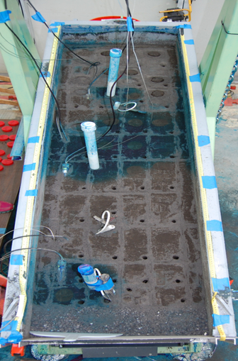 Hydraulic conductivity experiment; permeameter setup with sensors, soil column; flow analysis.