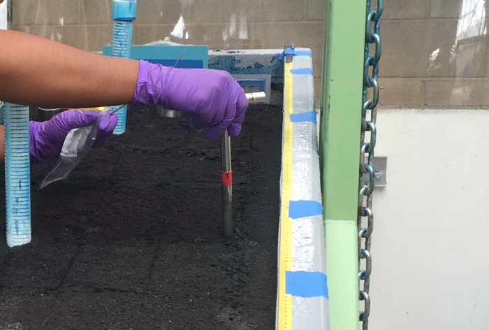Soil sampling process in a field experiment with soil probe and measurement equipment.