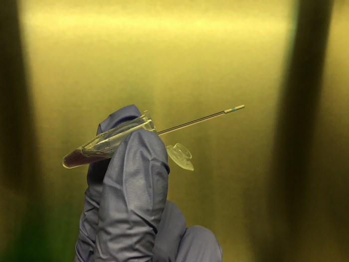 Micropipette extraction, microtube handling, lab technique, gloved hand, research equipment.