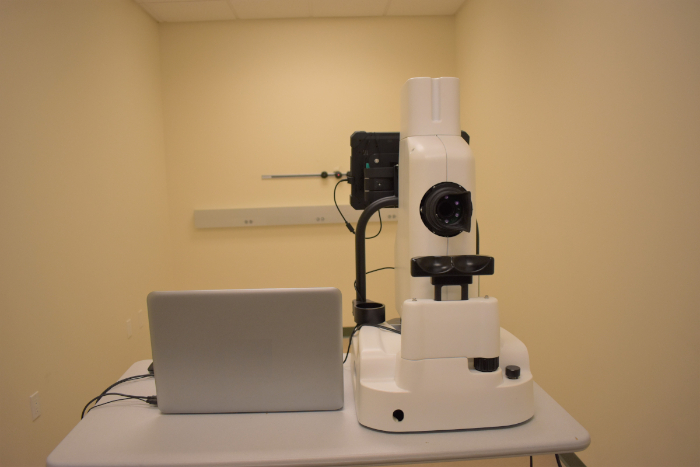 Optical microscopy workstation setup for specimen imaging; includes microscope and connected laptop.