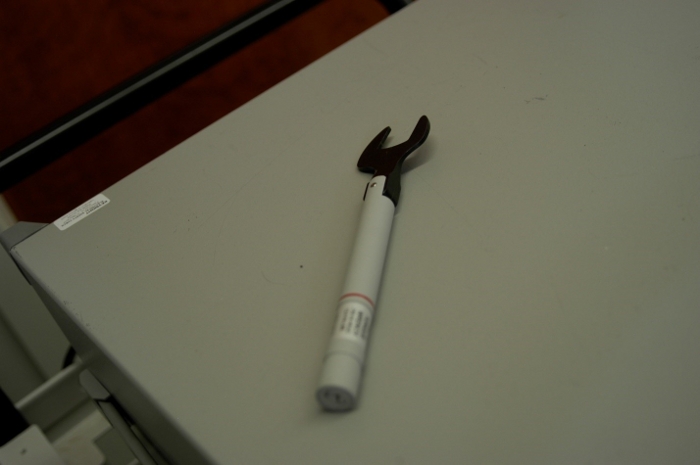 figure-results-4 Wrench-shaped pen tool on desk surface, office environment, industrial design concept.