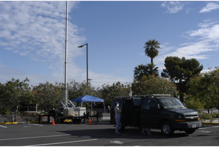 figure-results-8 Mobile surveillance unit with telescopic mast in parking lot, showcasing radar or communication setup.