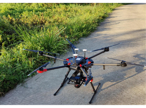 Hexacopter drone on pavement, used for aerial surveys and data collection in environmental studies.