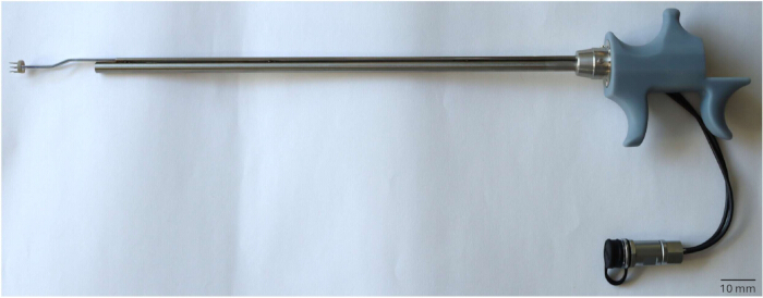 Surgical tool for laparoscopic procedures; handle, shaft, and attachment seen; used in minimally invasive surgery.