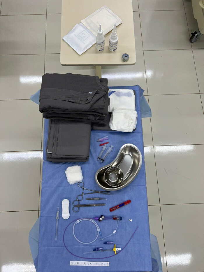 Surgical preparation setup with instruments, syringes, sterile drapes, antiseptic for medical procedures.