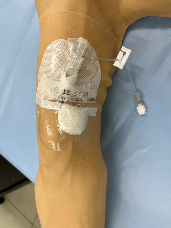 Intravenous catheter placement demonstration on mannequin arm for medical training.